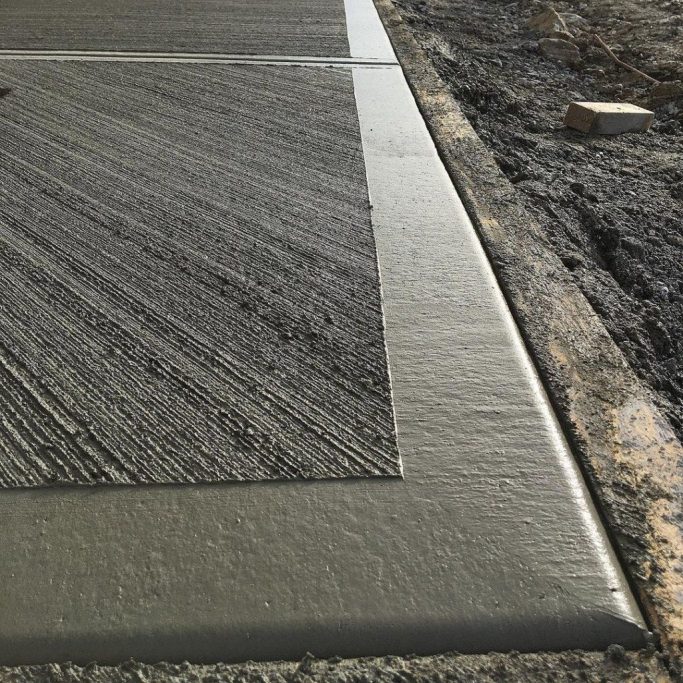 The decorative corner of a patio to show the finishing touches of the concrete. The concrete has a design on the base and a smooth outline