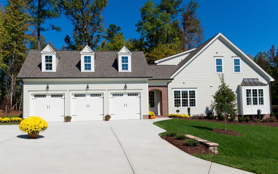 Newly installed smooth concrete driveway designed to accommodate three cars. The driveway features a sleek, even surface with clean lines