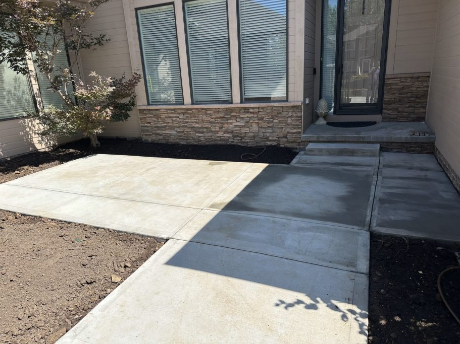 A completed concrete project showcasing the finished front entrance and home courtyard 