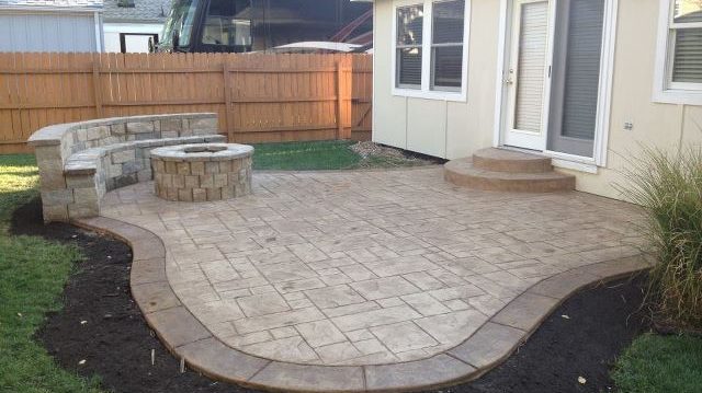 Concrete stone patio for hosting with built in stone bench and fire pit