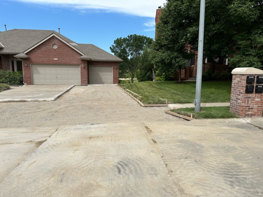 Paved and leveled area in a driveway extension project, prepared to add a concrete third car space