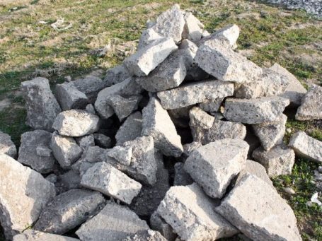 Small pile of broken concrete chunks with varying sizes and irregular shapes. The chunks are showing rough, jagged edges. The pile appears to be a collection of debris from a larger broken concrete surface