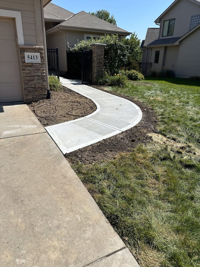 A completed concrete project showcasing the finished front entry sidewalk that leads to the homes front door